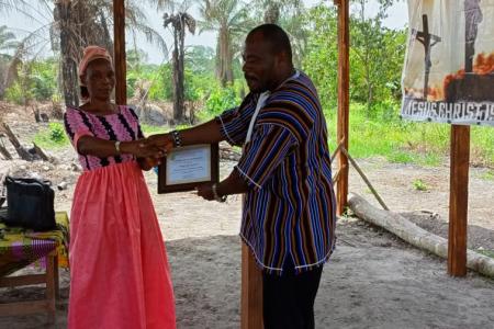 Rev. Willington Greene International Missions Director of Rhema Pentecostal Church certificating one of his members after a week long revival 